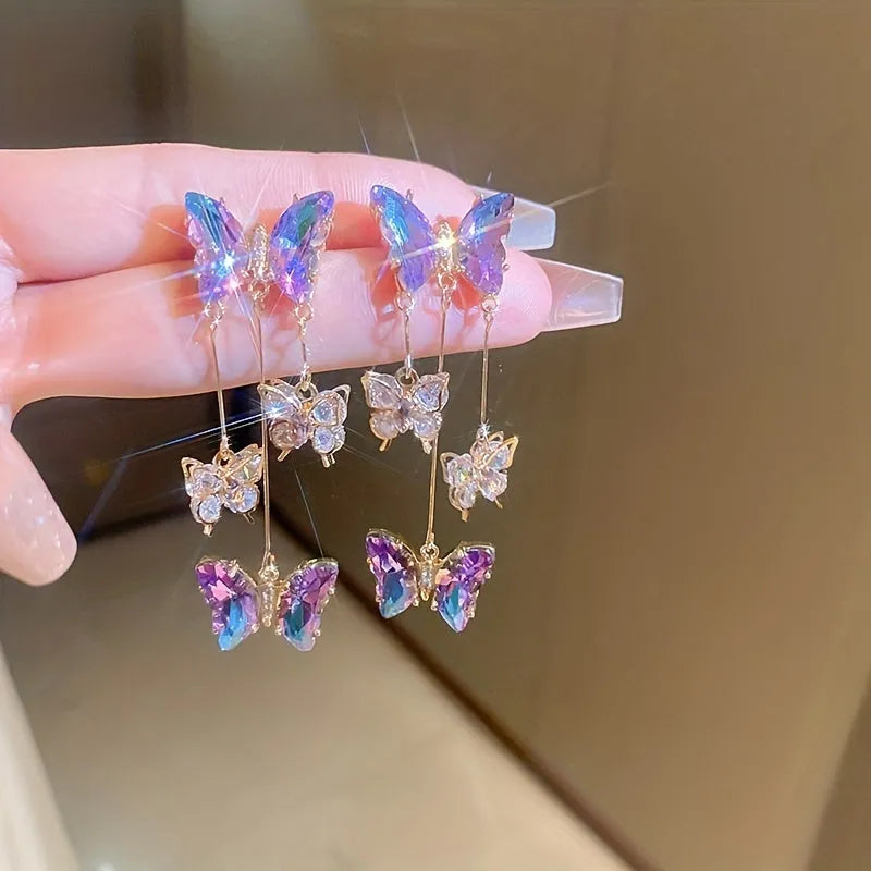 Close-up of women's silver needle blue purple butterfly tassel earrings with crystal flowers on alloy.