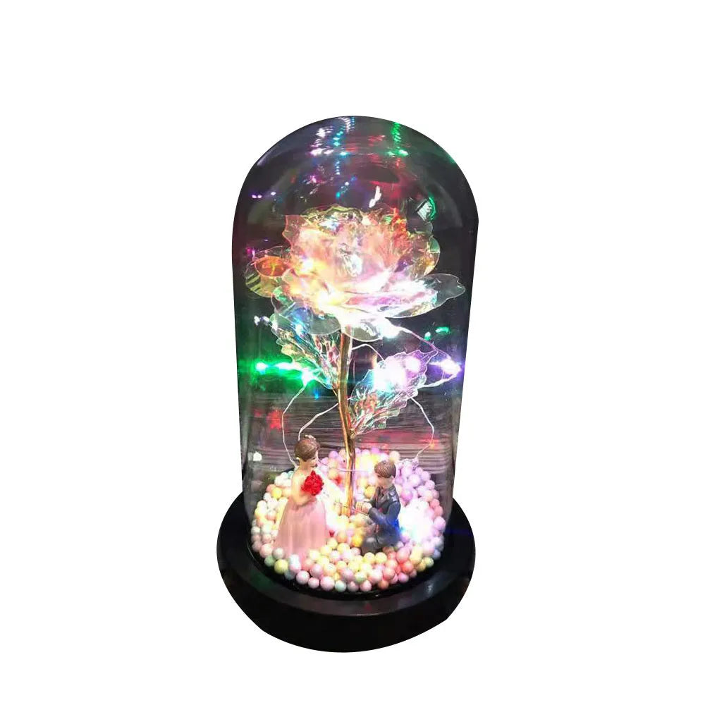 Artificial gold rose in glass flask with LED lights on black base, 20cm tall