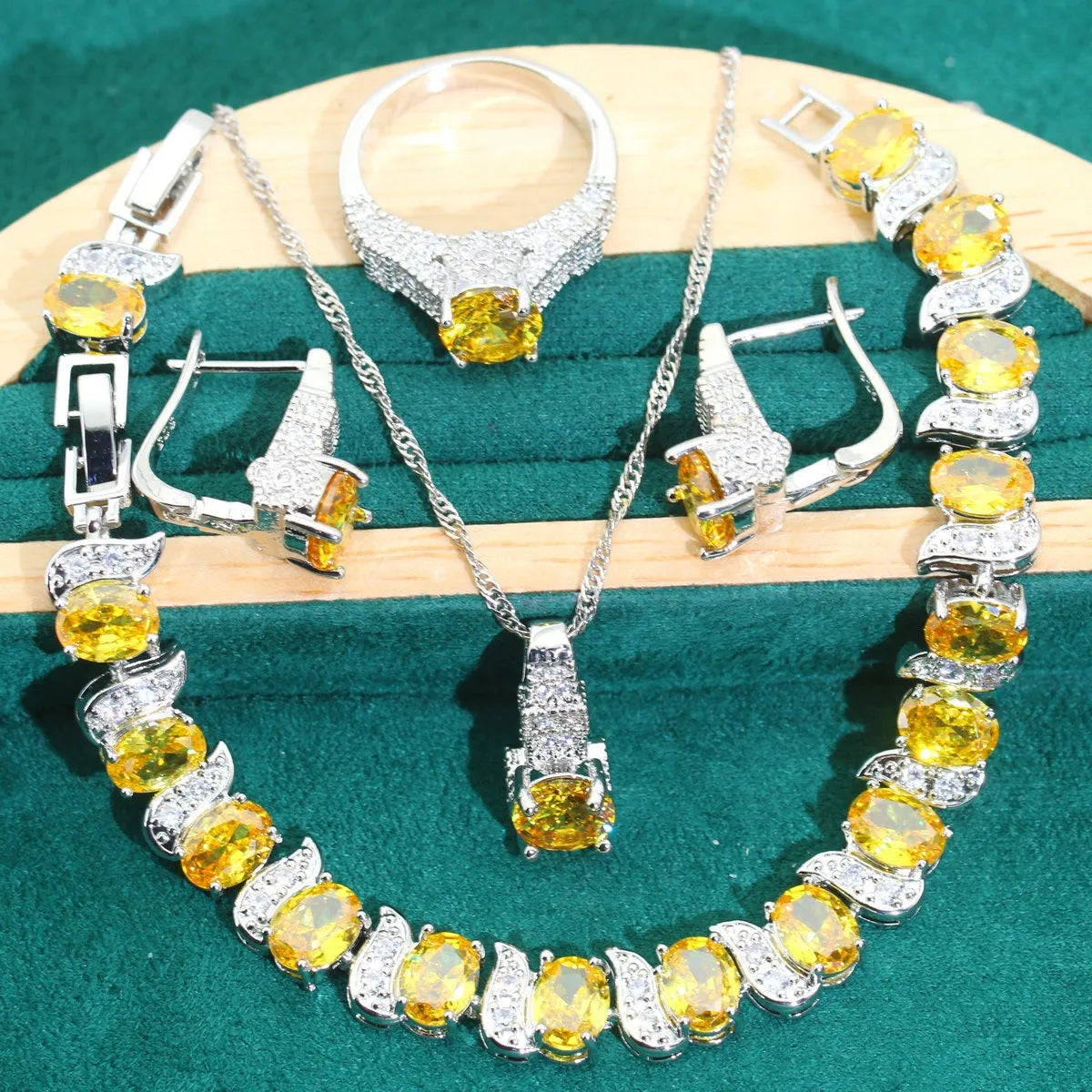 Bridal jewellery four-piece set with zircon pendants showing necklace, bracelet, earrings and ring with water wave chain design