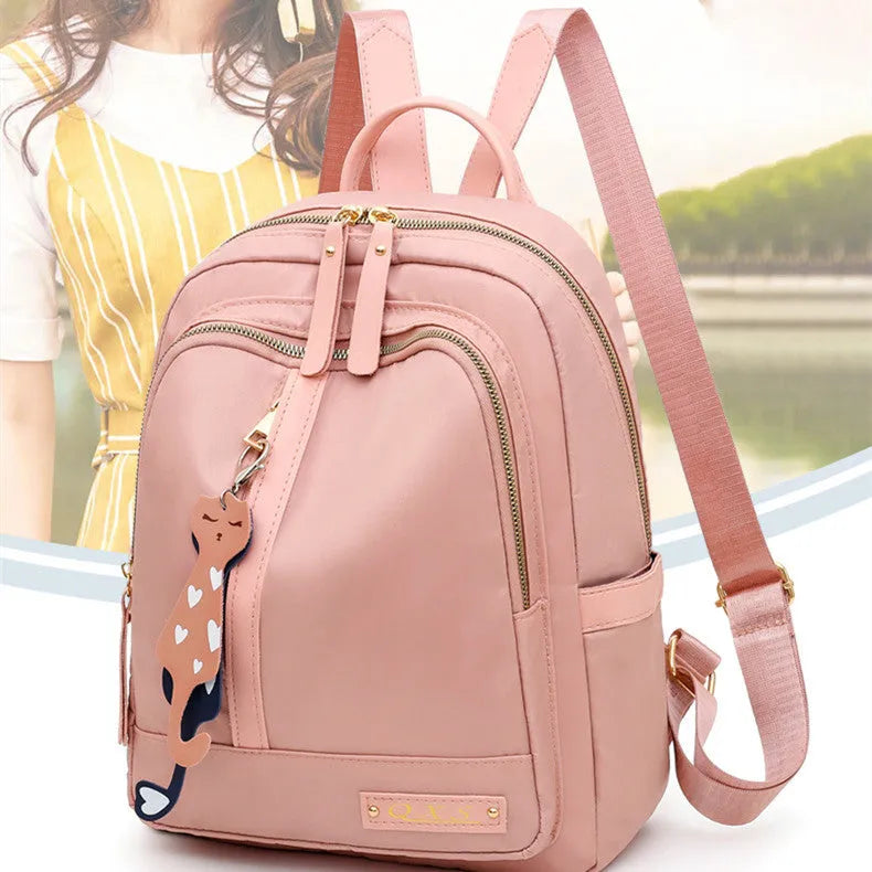 Women's black nylon casual backpack with double shoulder straps, soft handle, and front pocket.