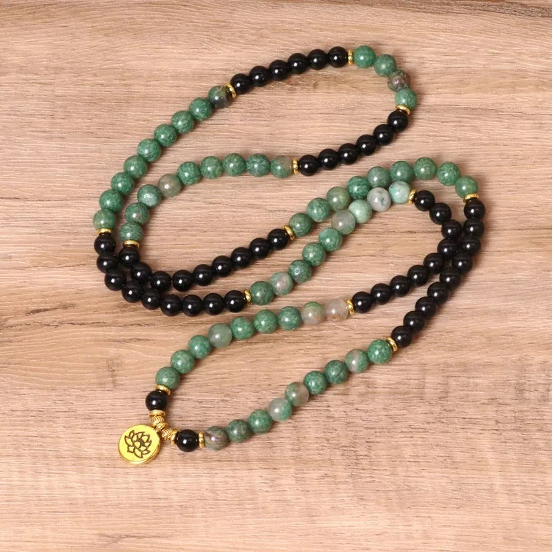 Green and black alloy beaded elastic bracelet laid flat showing alternating colour pattern