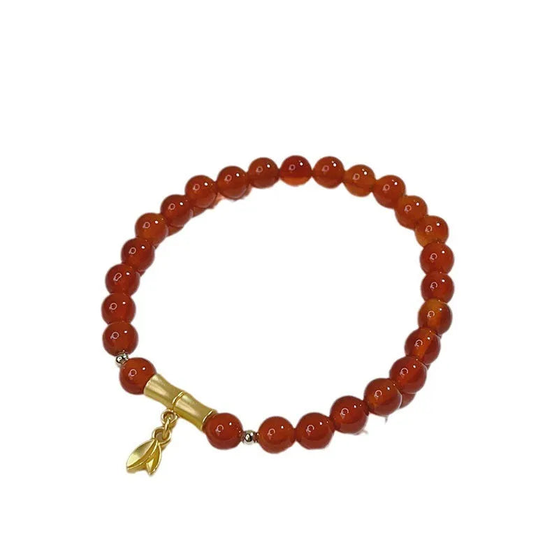 Handmade red agate bracelet with dragon motif and lucky charm beads.