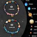 Two natural stone beaded zodiac bracelets with adjustable cords on a wooden surface.
