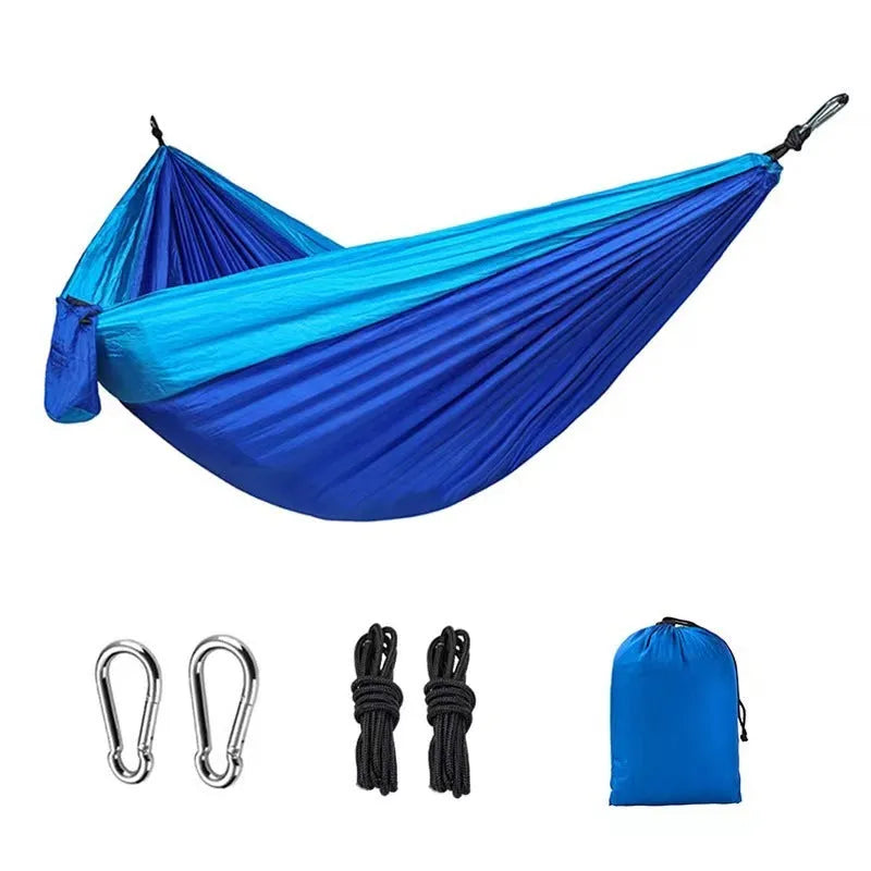 Blue parachute cloth nylon camping hammock shown hung between trees.