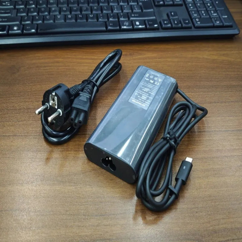 Black 65W USB-C laptop power adapter with multiple international plug attachments