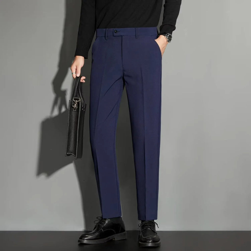 Men's straight-fit ankle-length suit trousers in a light gray colour, showing the draping effect.
