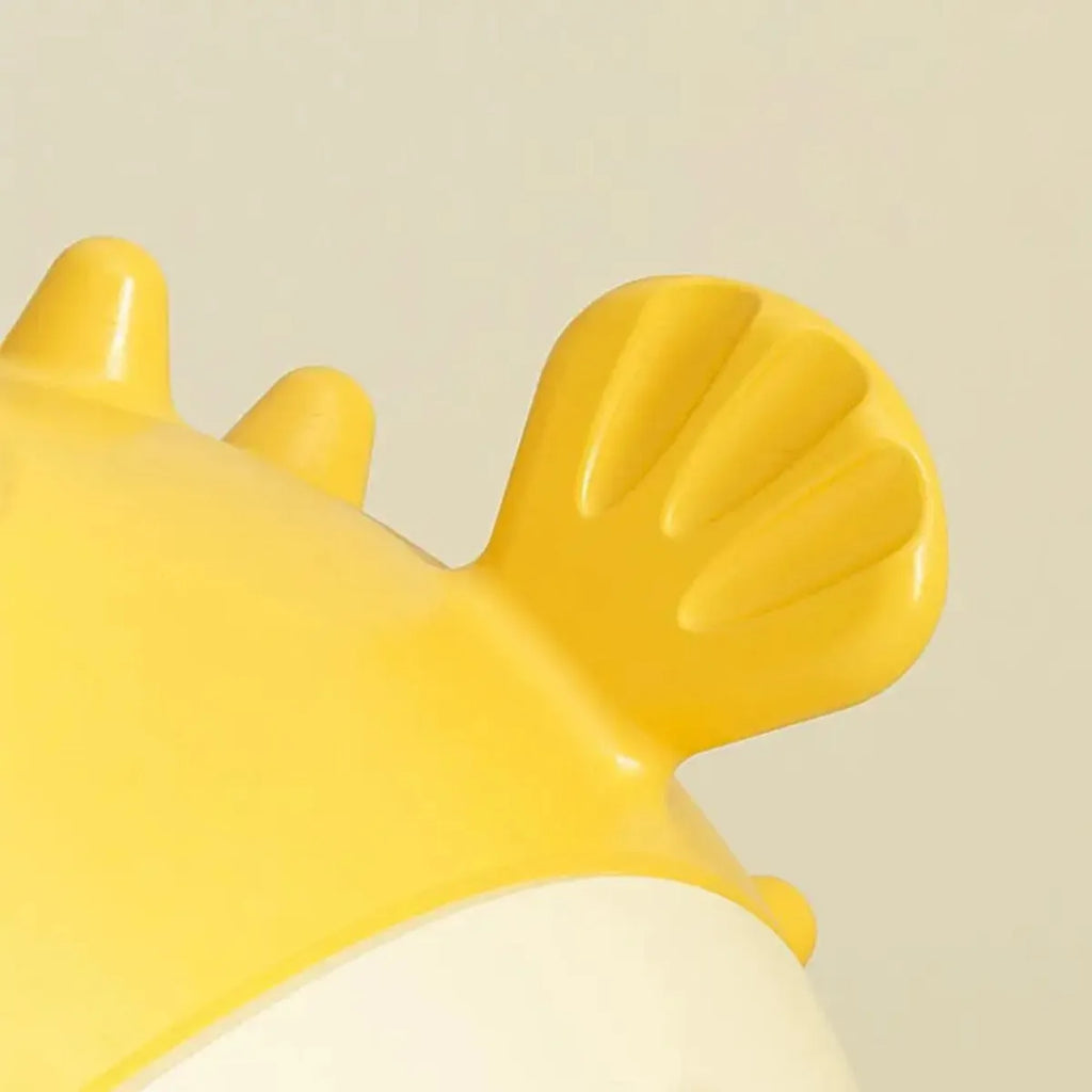 Yellow fish-shaped vinyl dog chew toy with textured surface and squeaker.