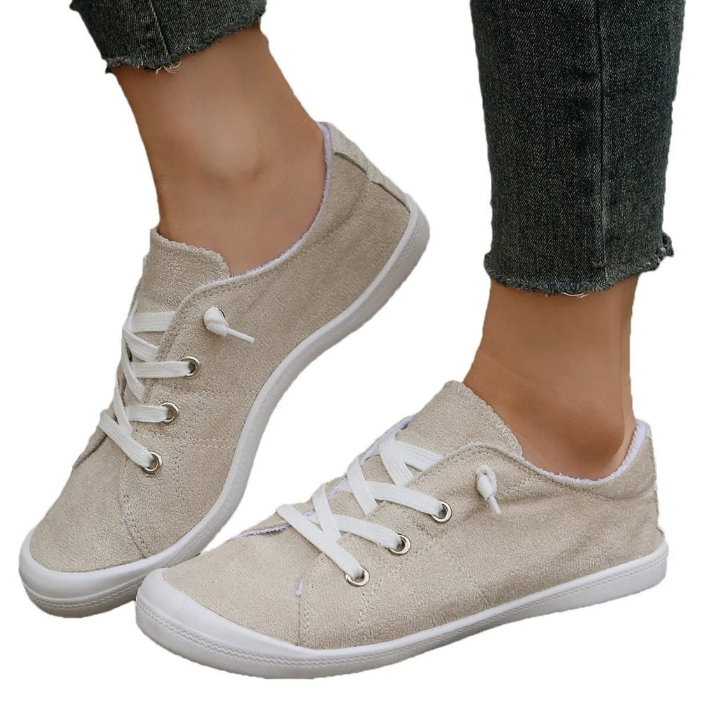 Women's creamy white fabric casual sneakers with rubber soles showing low-top design