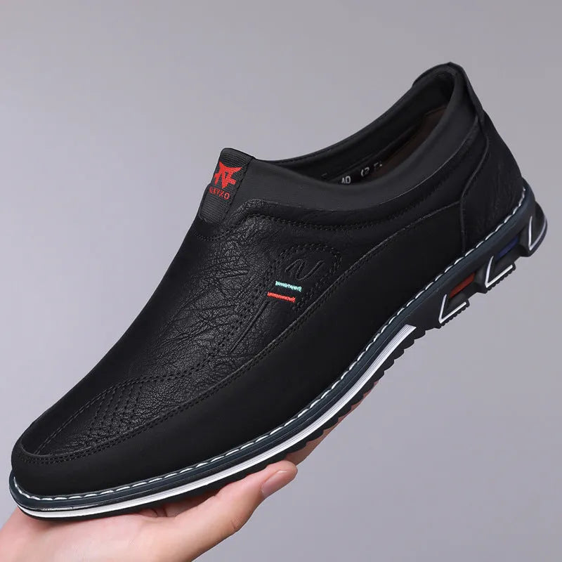 Men's black leather casual shoes with a low top, rubber sole, and sewing line detail on a fabric upper.
