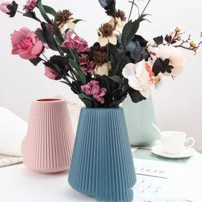 Colourful melamine plastic decorative flower vase on a desktop, 16cm wide by 20cm tall.