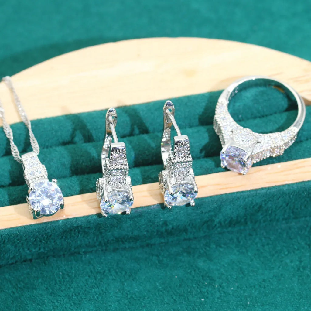 Bridal jewellery four-piece set with zircon pendants showing necklace, bracelet, earrings and ring with water wave chain design