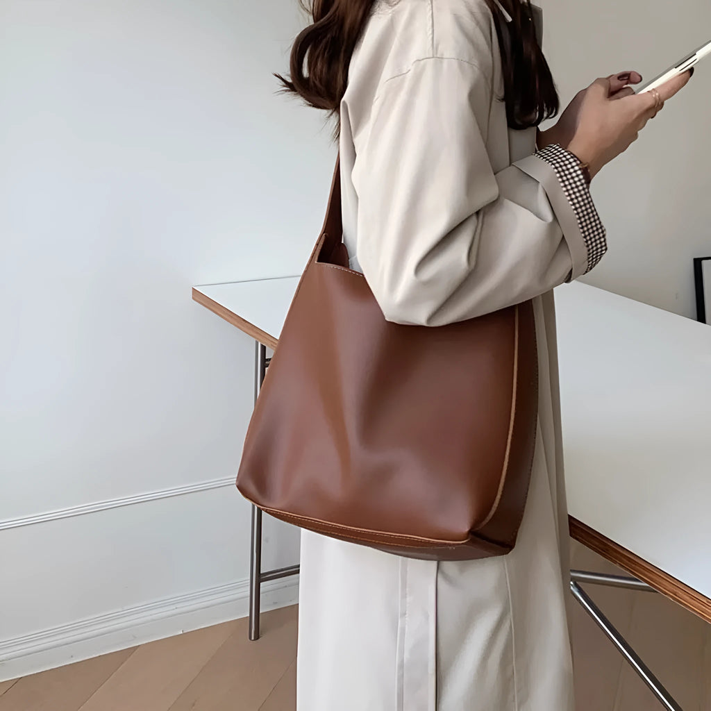 Women's soft PU shoulder bag with swing threads in black ribbon or brown colour options