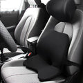 Black memory foam car waist cushion for lumbar support placed on a car seat.