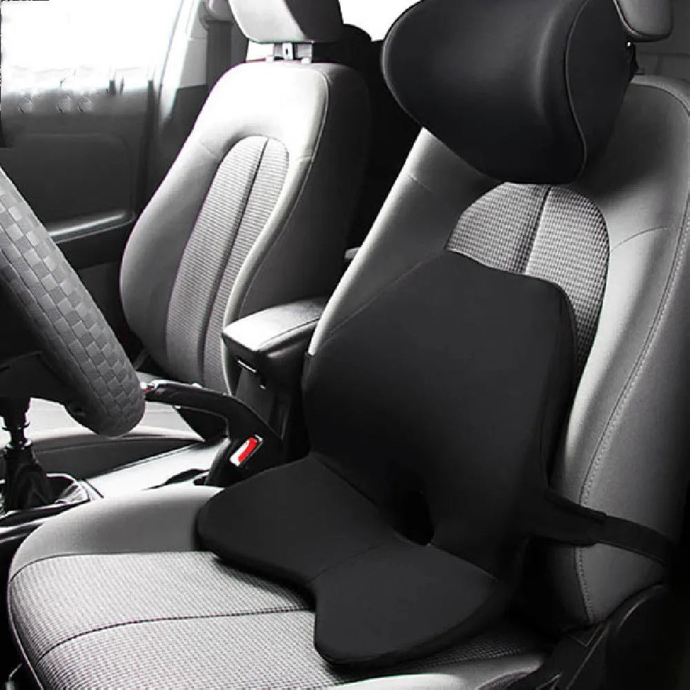 Black memory foam car waist cushion for lumbar support placed on a car seat.