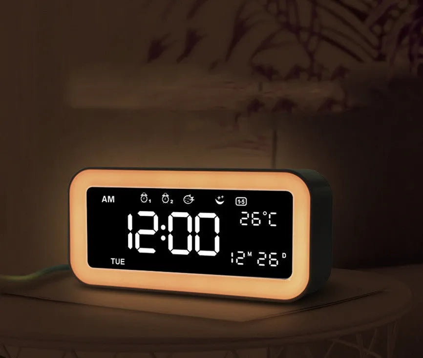 Blue rectangular LED atmosphere light alarm clock with digital display on a wooden desk.