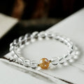 Unisex obsidian black agate white crystal bracelet with 10mm and 8mm beads on neutral background