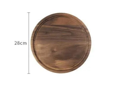 Black walnut wood double-sided cutting board with juice groove and side handle on kitchen counter