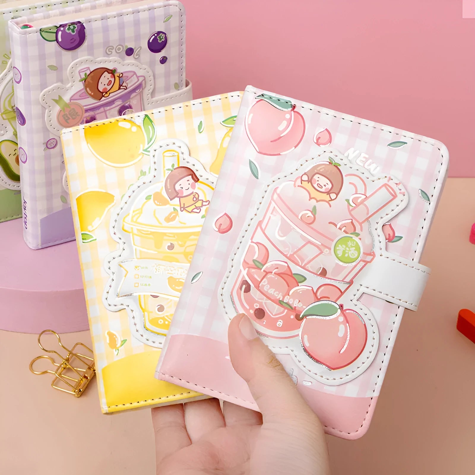 Cute magnetic buckle notebook with heart design in pink, yellow, green, and purple colours on white background