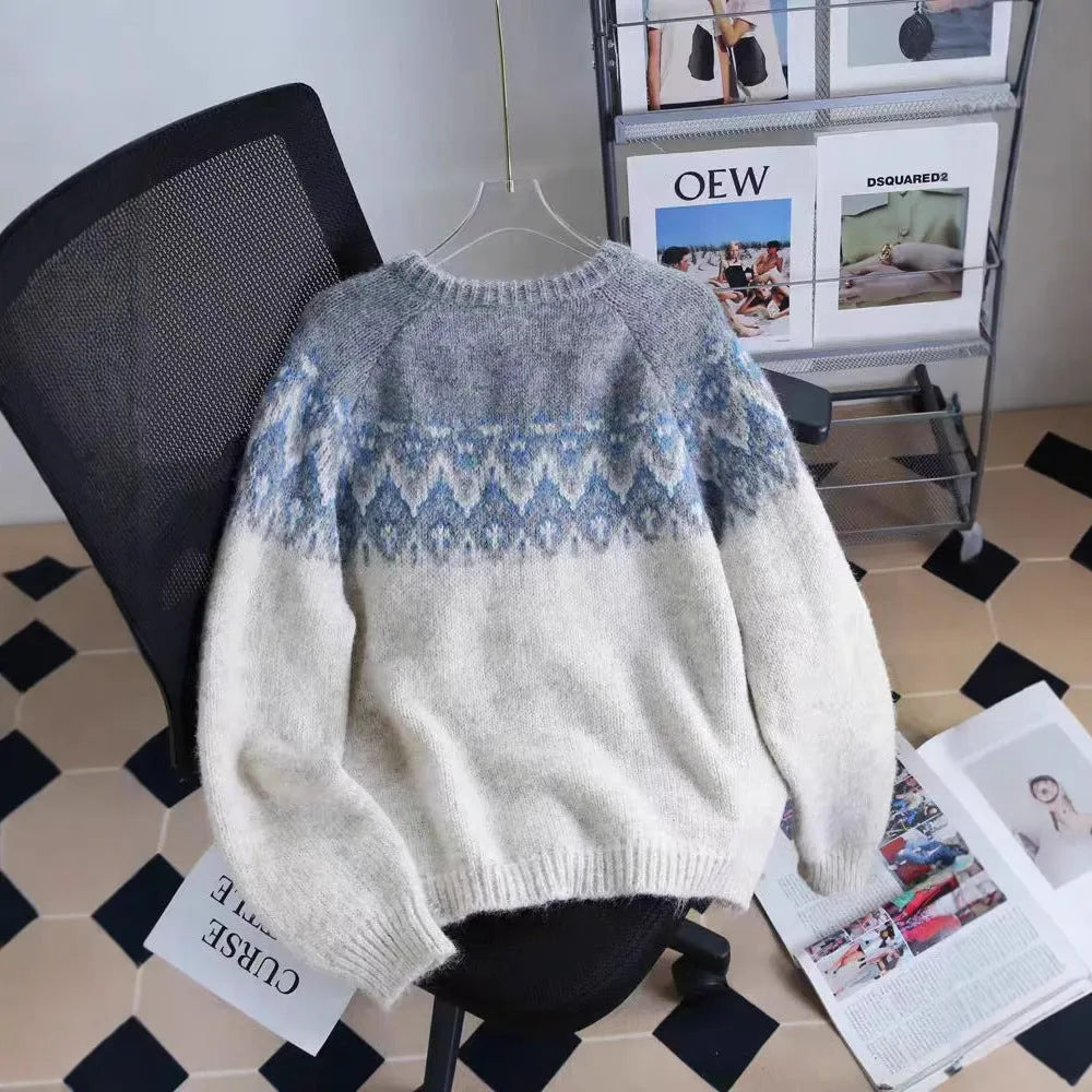 Women's beige jacquard knit sweater coat with loose fit and long sleeves on a hanger.