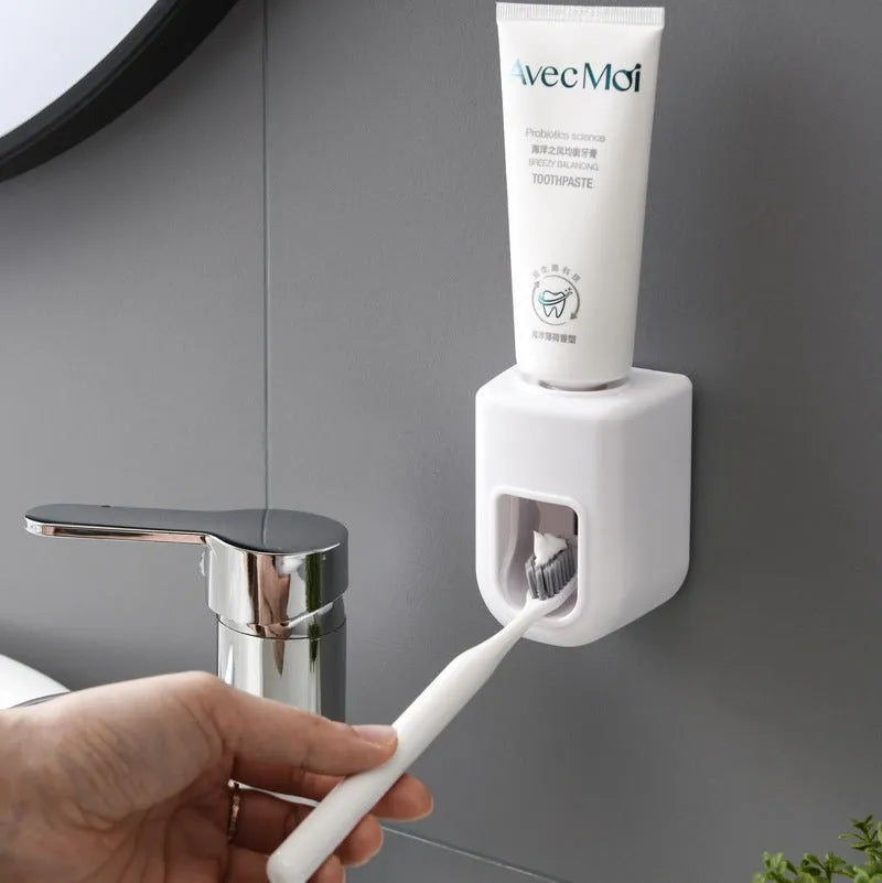 Automatic toothpaste dispenser wall-mounted in blue, with push button and toothpaste nozzle, 9 x 6 x 6 cm