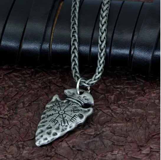 Alloy compass pendant necklace with twisted chain on a flat surface showing silver finish