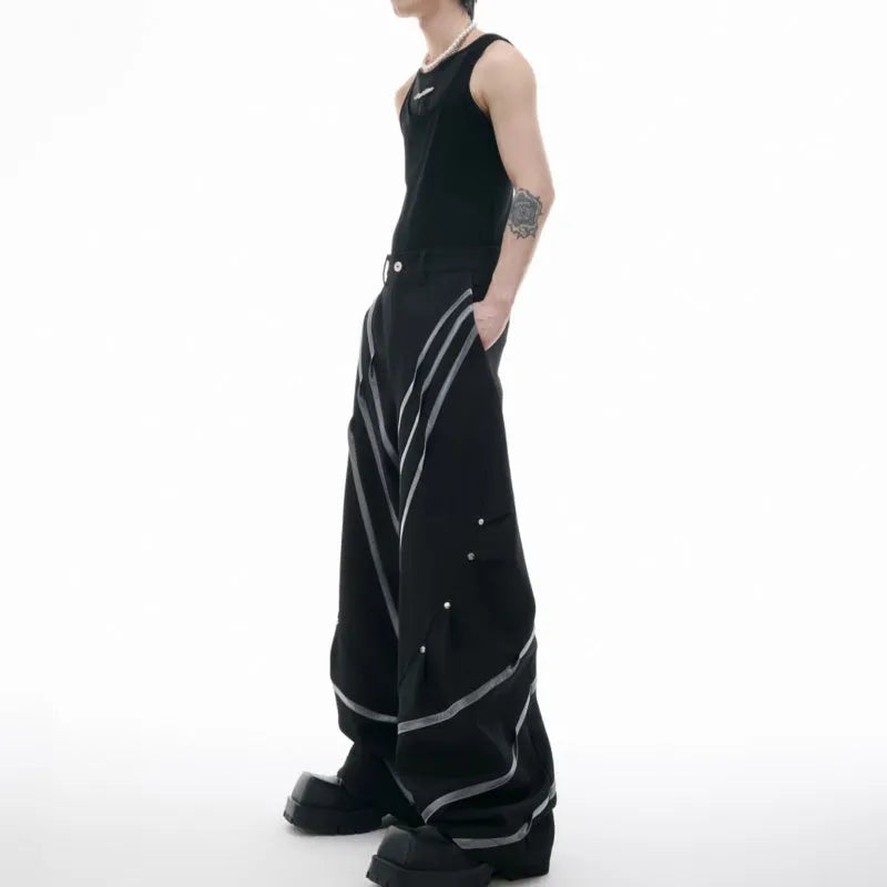 Men's black trousers with metal striped rivet details, pleated front, and a structured three-dimensional cut.