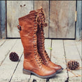 Women's black cross strap knight ankle boots with front laces and side buckle on a solid colour background.
