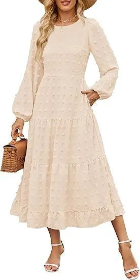 A woman wearing a beige high waist long sleeve dress with ruffle details on a autumn day.