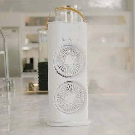 White double-ended spray fan with humidifying mist and remote control on a desk