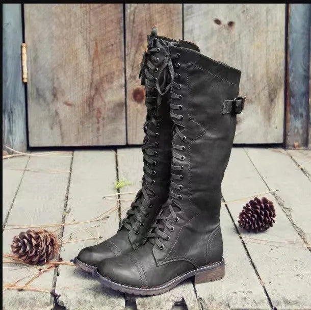Women's black chunky heel high leg boot with round toe and low stout heel on a solid background.