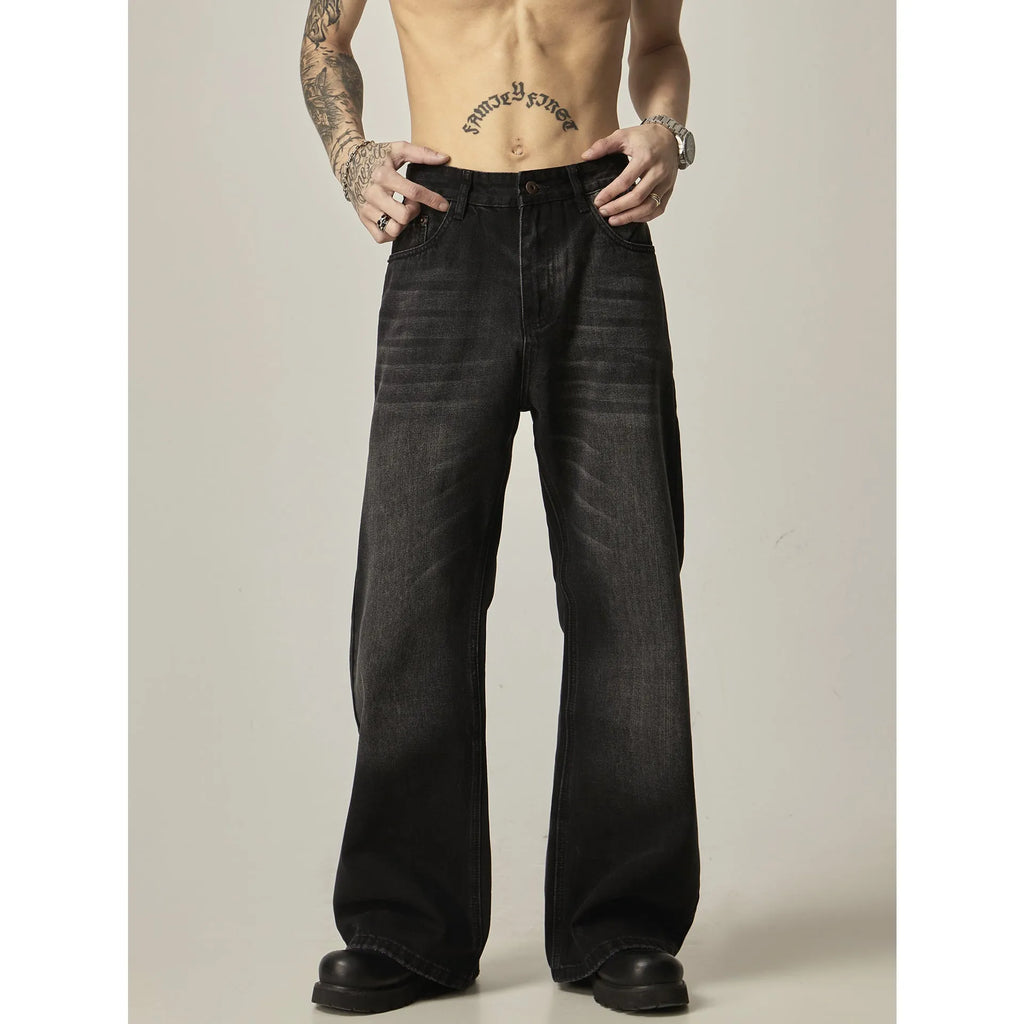 Man's black loose-fit straight-leg jeans with a retro style on a plain background.