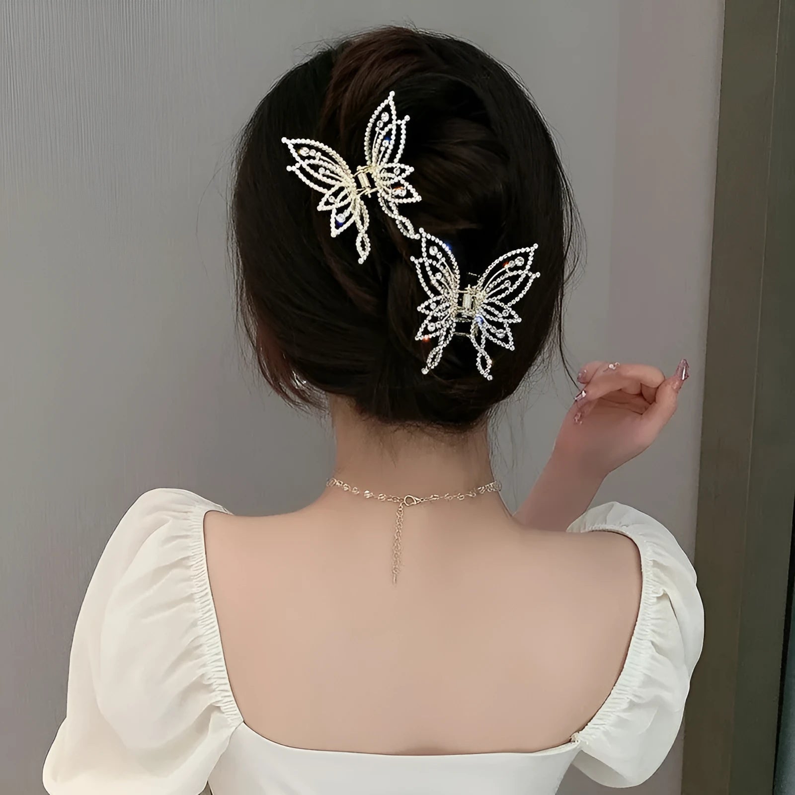 Butterfly-shaped alloy hair barrette for women with pearl or rhinestone decoration, shown from the front.