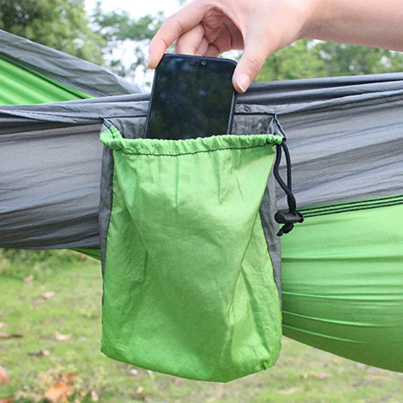 Blue parachute cloth nylon camping hammock shown hung between trees.