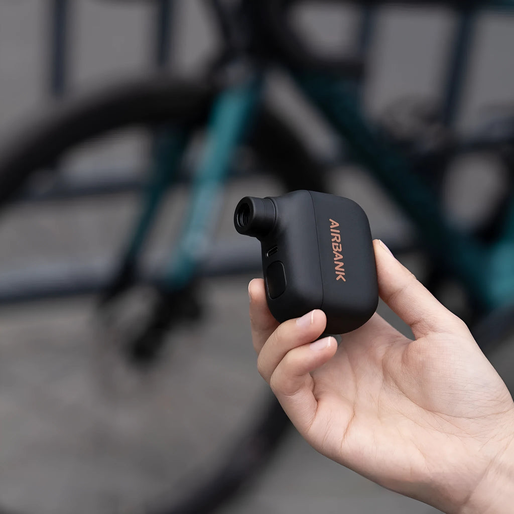 Black AS100 mini electric bicycle pump with USB charging cable and waterproof storage bag
