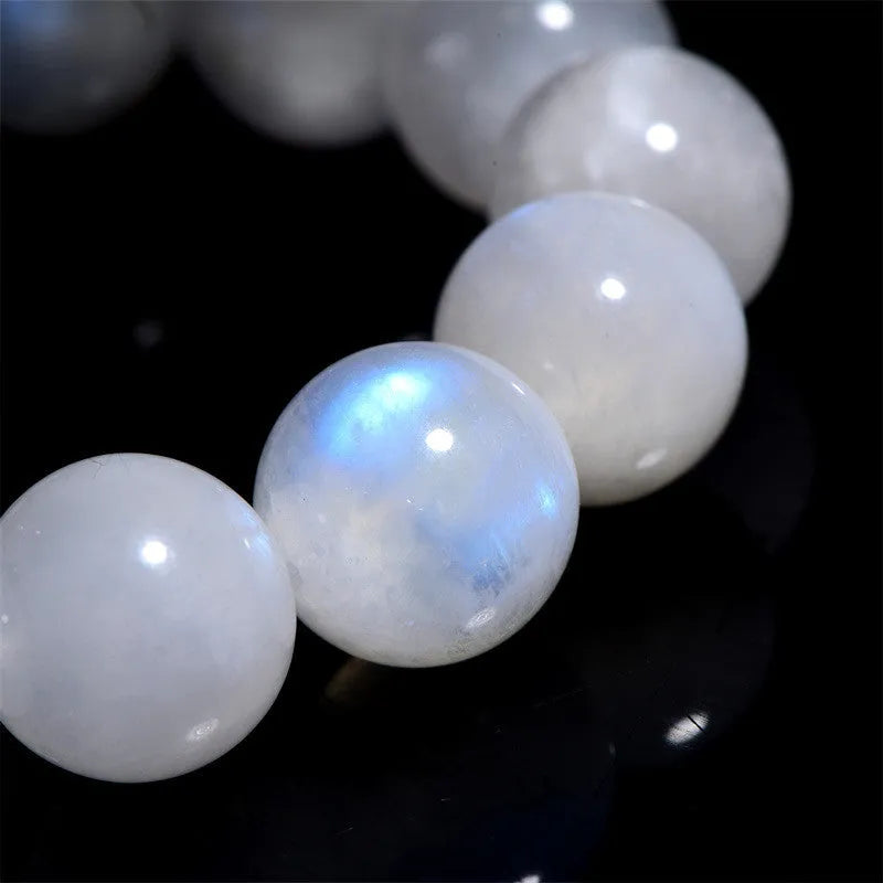 White polished moonstone bead bracelet with blue moonlight sheen, showing round geometric beads.