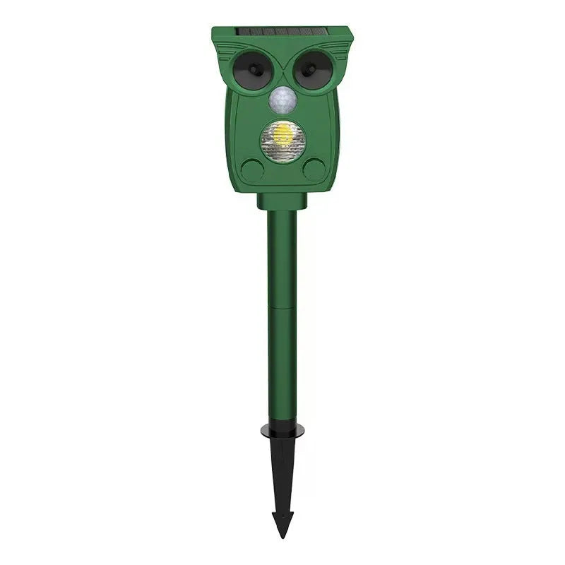 Dark green solar-powered infrared animal repeller with plastic body on grass