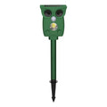 Dark green solar-powered infrared animal repeller with plastic body on grass