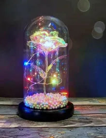 Artificial gold rose in glass flask with LED lights on black base, 20cm tall