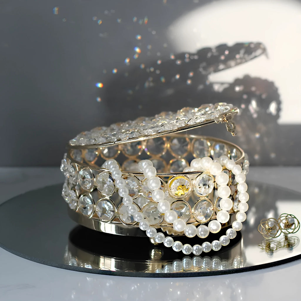 Clear crystal glass jewellery box with a French gold metal frame on a table.