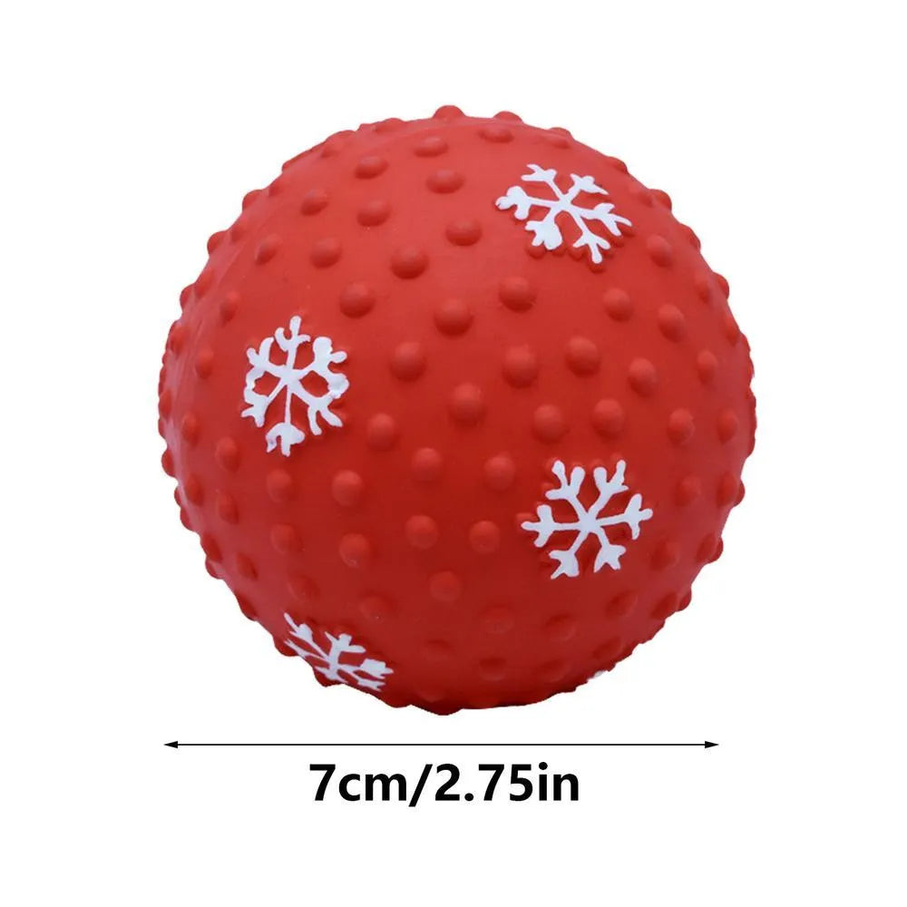 Red dog toy ball with snowflake print pattern, 7cm diameter, bouncing on grass