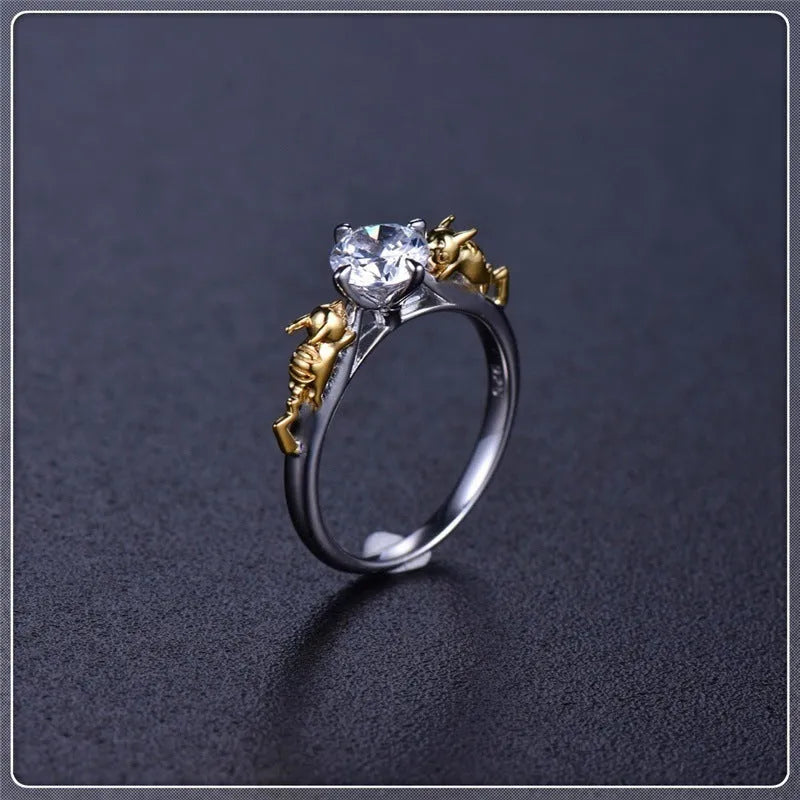 Copper crown ring with crystals in a black gold finish, shown on a finger.