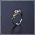 Copper crown ring with crystals in a black gold finish, shown on a finger.