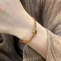 Natural tiger's eye and Hetian jade bracelet with diamond treatment showing golden gourd pattern