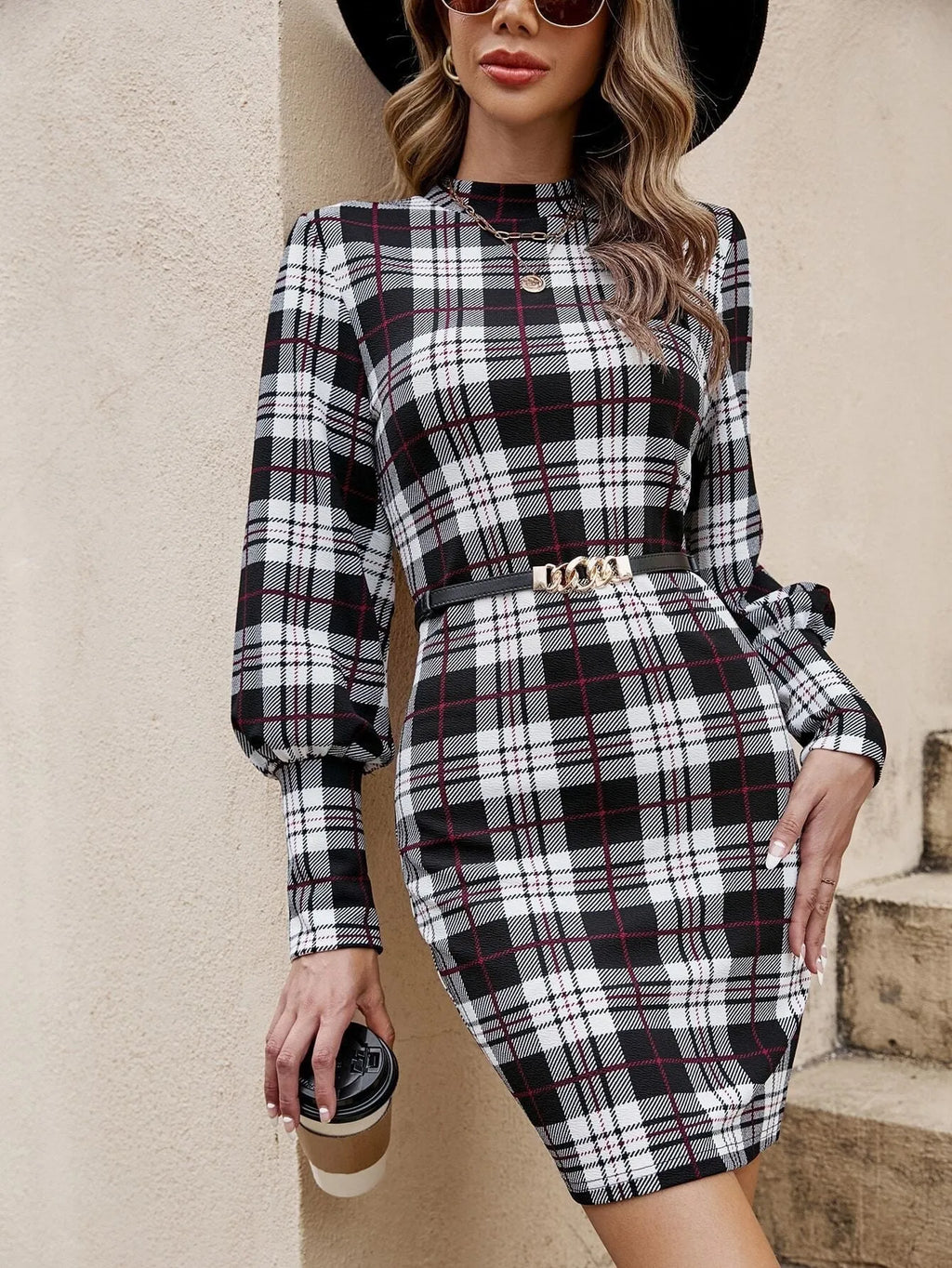 Black tight-fitting dress with lantern sleeves and leather stitch detail.