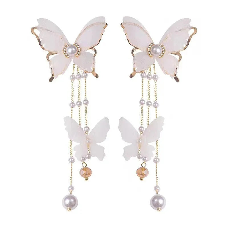 White butterfly earrings with pearl and rhinestone details and tassel design
