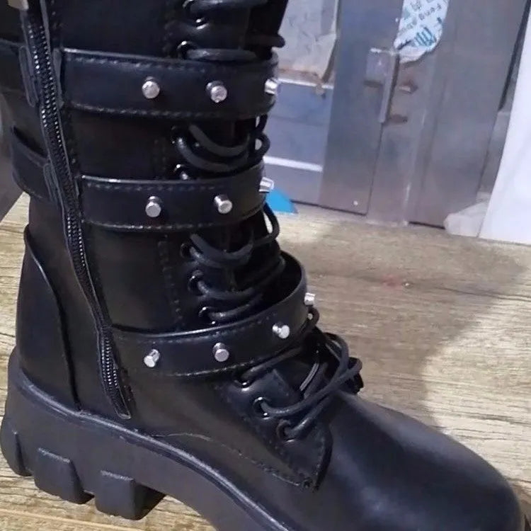 Women's black knee-high boots with metal buckle straps and a side zipper closure.