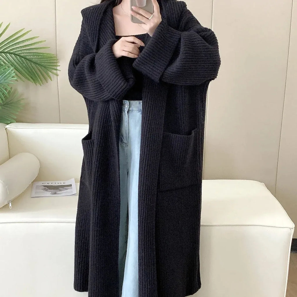 Women's loose grey hooded cardigan coat with raglan sleeves on a hanger