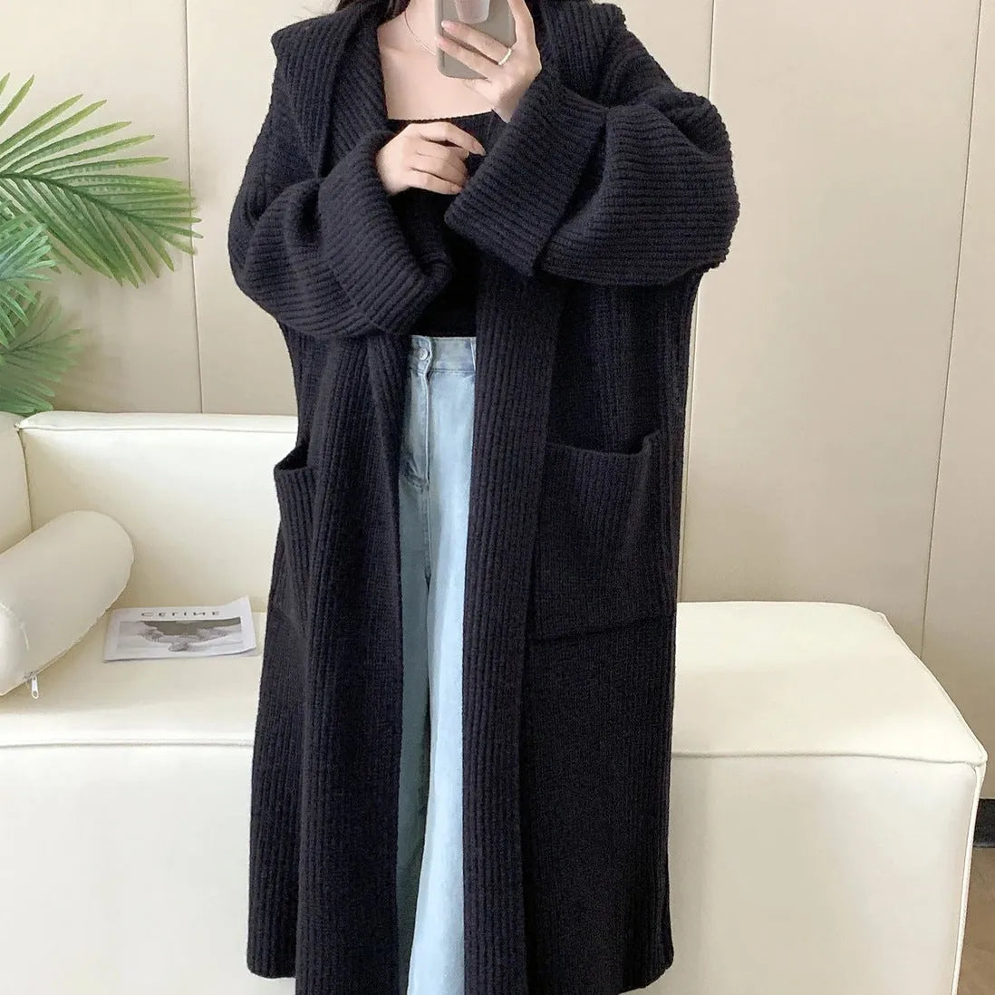 Women's loose grey hooded cardigan coat with raglan sleeves on a hanger