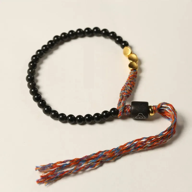 Obsidian coloured hand-woven leather strap bracelet with adjustable fastening on a wrist.