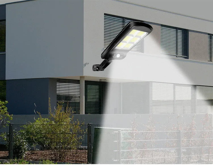 Black outdoor solar-powered motion sensor light mounted on a wall with solar panel visible.